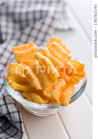 Crispy salted chips in bowl on white table. Crispy salted chips in bowl on white table. 136762145