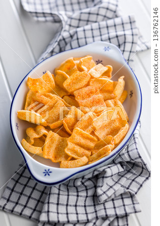 Crispy salted chips in bowl on white table. Crispy salted chips in bowl on white table. 136762146