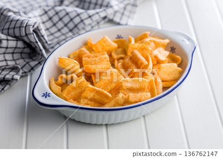 Crispy salted chips in bowl on white table. Crispy salted chips in bowl on white table. 136762147