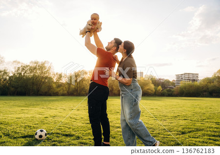 Happy couple parents are with little baby outdoors 136762183