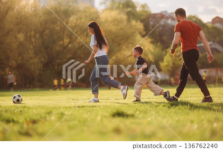Soccer game. Family of mother, father and son are playing on the field 136762240
