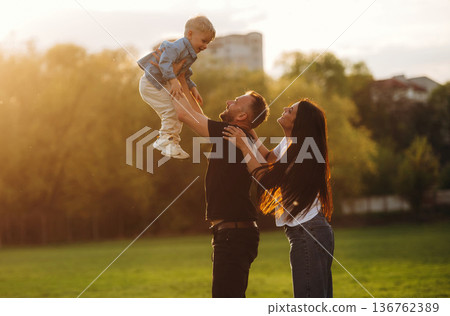 Family of mother, father and son are playing on the field 136762389