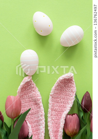 Easter Eggs with Bunny Ears and Tulips on Green Background. Spring Holiday Composition Easter Eggs with Bunny Ears and Tulips on Green Background. Spring Holiday Composition 136762497