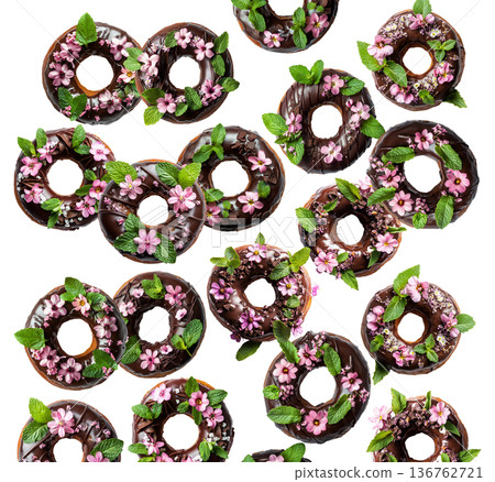 Chocolate glazed donuts topped with pink edible flowers and mint leaves, isolated on a white background Chocolate glazed donuts topped with pink edible flowers and mint leaves, isolated on a white background 136762721