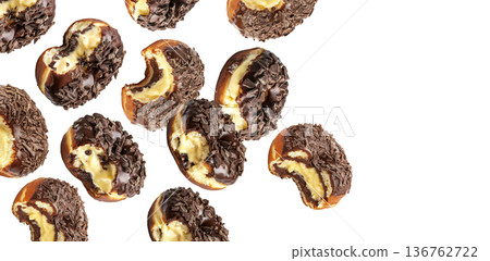 Chocolate glazed cream filled donuts with visible bite marks, isolated on white background. Concept of sweet dessert pattern Chocolate glazed cream filled donuts with visible bite marks, isolated on white background. Concept of sweet dessert pattern 136762722