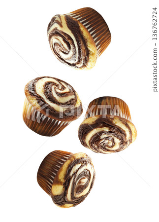Delicious chocolate marble muffins in scattered layout, isolated on white background. Concept of sweet bakery treats 136762724