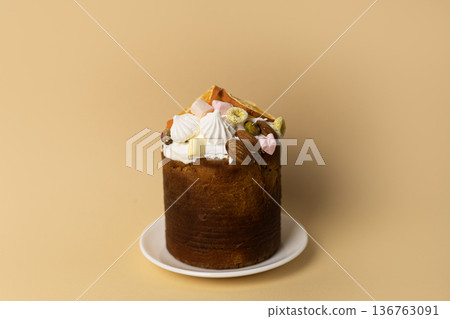 Homemade Easter bread topped with crunchy nuts and sweet marshmallows, minimal composition on pastel peach backdrop Homemade Easter bread topped with crunchy nuts and sweet marshmallows, minimal composition on pastel peach backdrop 136763091
