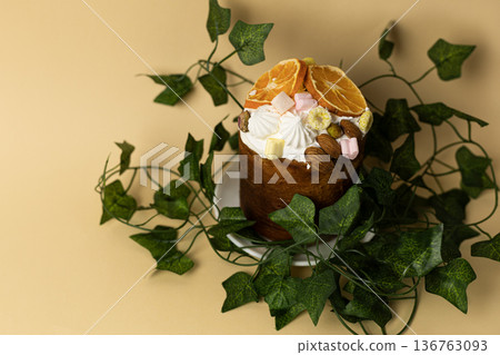 Festive Easter bread decorated with greenery, placed on soft pastel peach backdrop, seasonal bakery concept Festive Easter bread decorated with greenery, placed on soft pastel peach backdrop, seasonal bakery concept 136763093