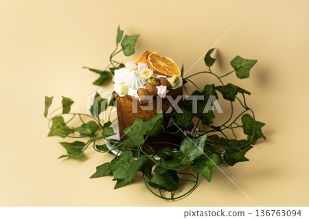 Traditional glazed Easter cake with decorative green leaves, minimalist composition on peach colored background Traditional glazed Easter cake with decorative green leaves, minimalist composition on peach colored background 136763094