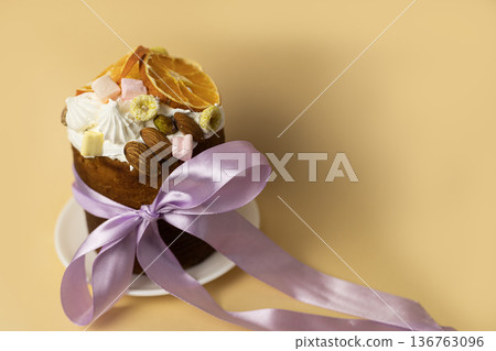Festive Easter bread topped with almonds and citrus slices, wrapped with soft violet ribbon, spring holiday dessert styling Festive Easter bread topped with almonds and citrus slices, wrapped with soft violet ribbon, spring holiday dessert styling 136763096