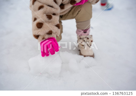 Close-Up of Child Hands Rolling Snowball 136763125