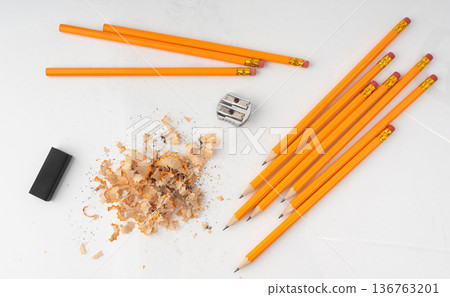 Sharpening pencils isolated. Yellow wooden graphite pencils with erasers, pencil shavings Sharpening pencils isolated. Yellow wooden graphite pencils with erasers, pencil shavings 136763201