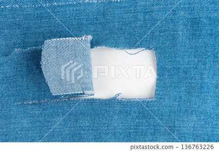 Torn fabric with a hole close-up. Damaged textiles background, old rip cotton material 136763226