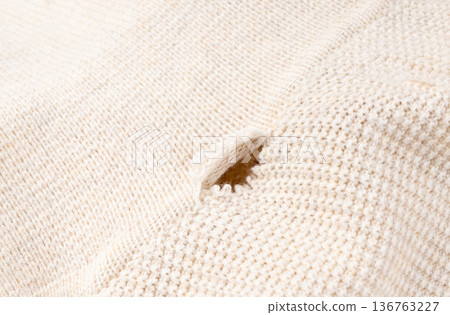 Torn fabric with a hole close-up. Damaged textiles background, old rip cotton material Torn fabric with a hole close-up. Damaged textiles background, old rip cotton material 136763227