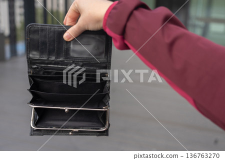Empty wallet in hands close-up. A black wallet with no money, poor person, economy crisis 136763270