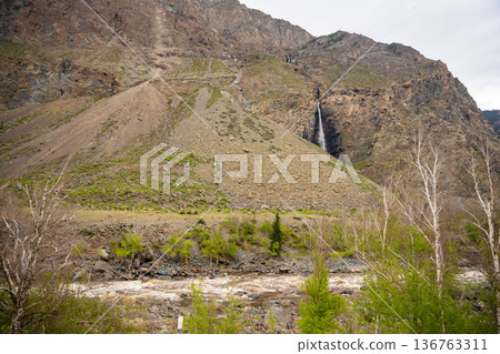 Mountain cliffs surrounding Chulyshman valley with visible waterfall Altai Russia Dramatic natural landscape with high rocks and falling water Mountain cliffs surrounding Chulyshman valley with visible waterfall Altai Russia Dramatic natural landscape with high rocks and falling water 136763311