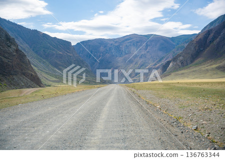 Gravel road running along Chulyshman river in mountain valley Altai Russia Remote travel route through scenic wilderness 136763344