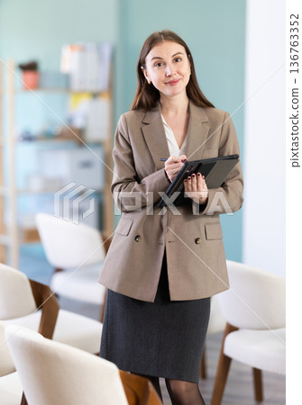 secretary woman with a tablet in her hands invites you to study secretary woman with a tablet in her hands invites you to study 136763352