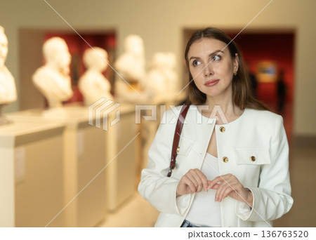 Thoughtful young woman in a sculpture museum 136763520