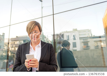 Business woman using smartphone outdoors Business woman using smartphone outdoors 136763538
