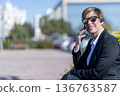 Businesswoman smiling while talking on smartphone 136763587