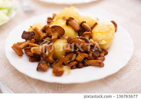 fried chanterelles with new potatoes on a white plate fried chanterelles with new potatoes on a white plate 136763677