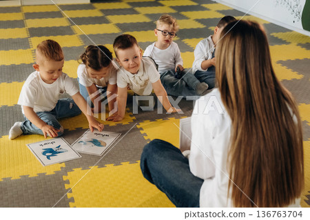 View behind the woman that is sitting and teaching. Children in kindergarten with their teacher 136763704