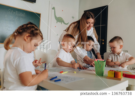 Helping the kids, education. Children in kindergarten with their teacher 136763738
