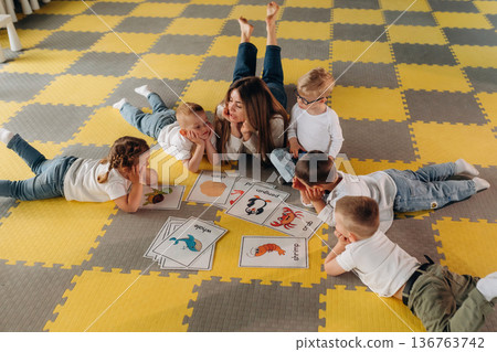 The process of learning words by images. Group of children are in the kindergarten 136763742