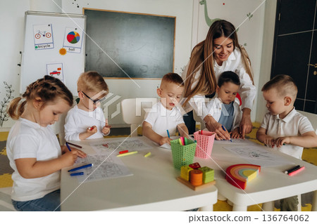 Having fun by learning. Children in kindergarten with their teacher 136764062