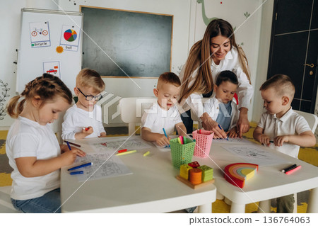Having fun by learning. Children in kindergarten with their teacher 136764063
