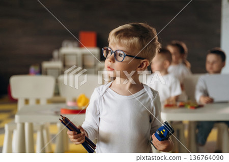 The pencils are in hands. Children in kindergarten with their teacher The pencils are in hands. Children in kindergarten with their teacher 136764090