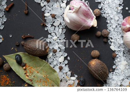 seasonings background with salt, Spices and garlic served at black. natural meal additives. healthy food concept. flat lay macro shot seasonings background with salt, Spices and garlic served at black. natural meal additives. healthy food concept. flat lay macro shot 136764109