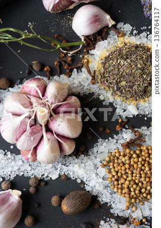seasonings background with salt, Spices and garlic served at black. natural meal additives. healthy food concept. flat lay macro shot seasonings background with salt, Spices and garlic served at black. natural meal additives. healthy food concept. flat lay macro shot 136764117