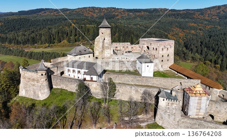 Aerial view of a well-preserved medieval stone castle on a hilltop. Aerial view of a well-preserved medieval stone castle on a hilltop. 136764208