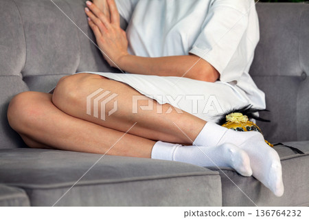 Close-up of the legs of a woman in white socks on the couch Close-up of the legs of a woman in white socks on the couch 136764232