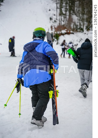 Man Carrying Skis Outdoors in Winter Man Carrying Skis Outdoors in Winter 136764245