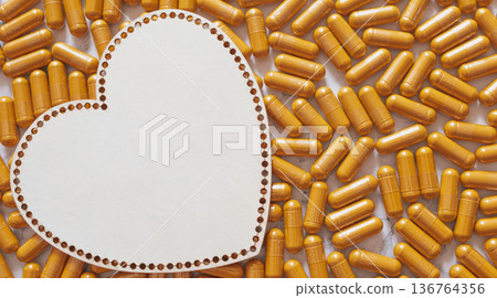 Heart-shaped wooden plate on vibrant curcumin capsules creating a warm and premium wellness scene, emphasizing love, health, natural supplements and concentrated benefits for heart Heart-shaped wooden plate on vibrant curcumin capsules creating a warm and premium wellness scene, emphasizing love, health, natural supplements and concentrated benefits for heart 136764356