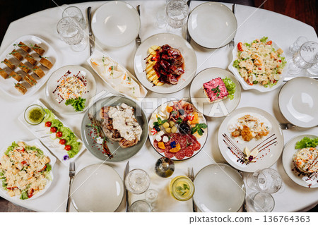 Festive banquet table with assorted dishes prepared for celebration dinner 136764363