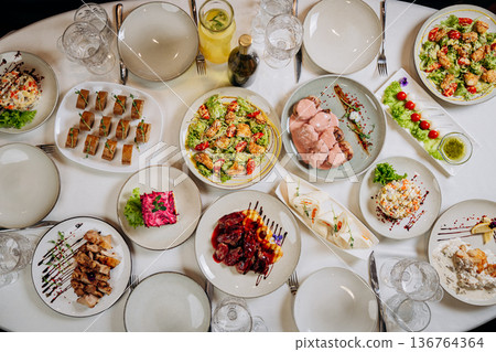 Top view of festive banquet table with assorted gourmet dishes and elegant serving Top view of festive banquet table with assorted gourmet dishes and elegant serving 136764364