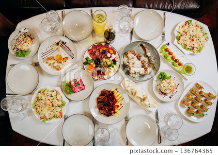 Top view of festive banquet table with assorted gourmet dishes and elegant serving Top view of festive banquet table with assorted gourmet dishes and elegant serving 136764365
