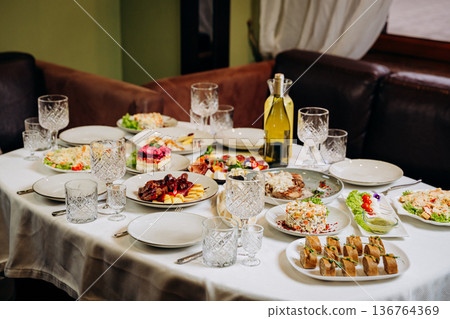 Festive banquet table with assorted gourmet dishes and appetizers ready for celebration Festive banquet table with assorted gourmet dishes and appetizers ready for celebration 136764369