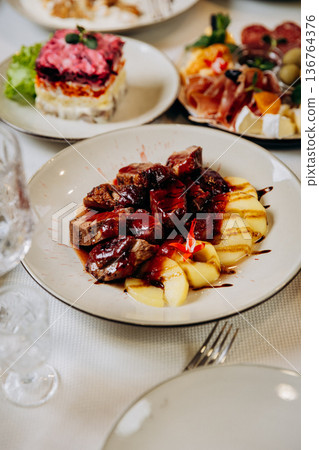 Gourmet meat dish with sauce and potatoes served at elegant restaurant dinner Gourmet meat dish with sauce and potatoes served at elegant restaurant dinner 136764376