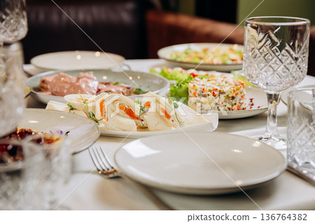 Lavash rolls with salmon and festive appetizers served on elegant restaurant table Lavash rolls with salmon and festive appetizers served on elegant restaurant table 136764382