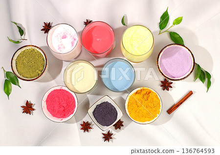 Various matcha tea lattes with milk on light background and matcha powder in cups. Traditional Indian trendy drink rich in antioxidants, used for weight loss and treatment, selective focus. 136764593