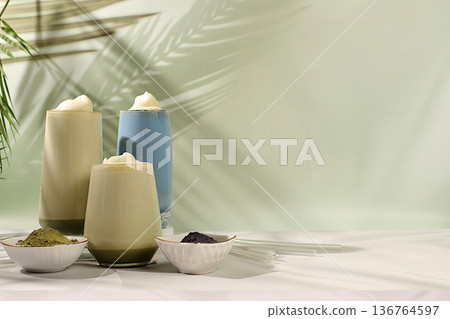Assortment of colorful Japanese matcha lattes with milk: green, blue, and moon milk drink against a sunny kitchen backdrop. This trendy, healthy drink promotes weight loss Assortment of colorful Japanese matcha lattes with milk: green, blue, and moon milk drink against a sunny kitchen backdrop. This trendy, healthy drink promotes weight loss 136764597