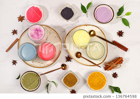 Various matcha tea lattes with milk on light background and matcha powder in cups. Traditional Indian trendy drink rich in antioxidants, used for weight loss and treatment, selective focus. Various matcha tea lattes with milk on light background and matcha powder in cups. Traditional Indian trendy drink rich in antioxidants, used for weight loss and treatment, selective focus. 136764598
