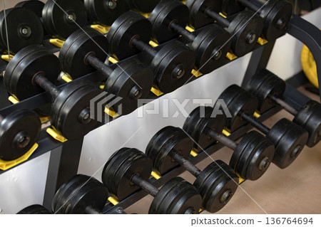 Dumbbells in a fitness center, closeup shot Dumbbells in a fitness center, closeup shot 136764694