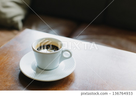 Cup of black coffee on a table in a cafe. Selective focus. Cup of black coffee on a table in a cafe. Selective focus. 136764933