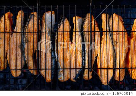 Grilling succulent salmon on a barbecue in the warm evening glow of summer's end Grilling succulent salmon on a barbecue in the warm evening glow of summer's end 136765014